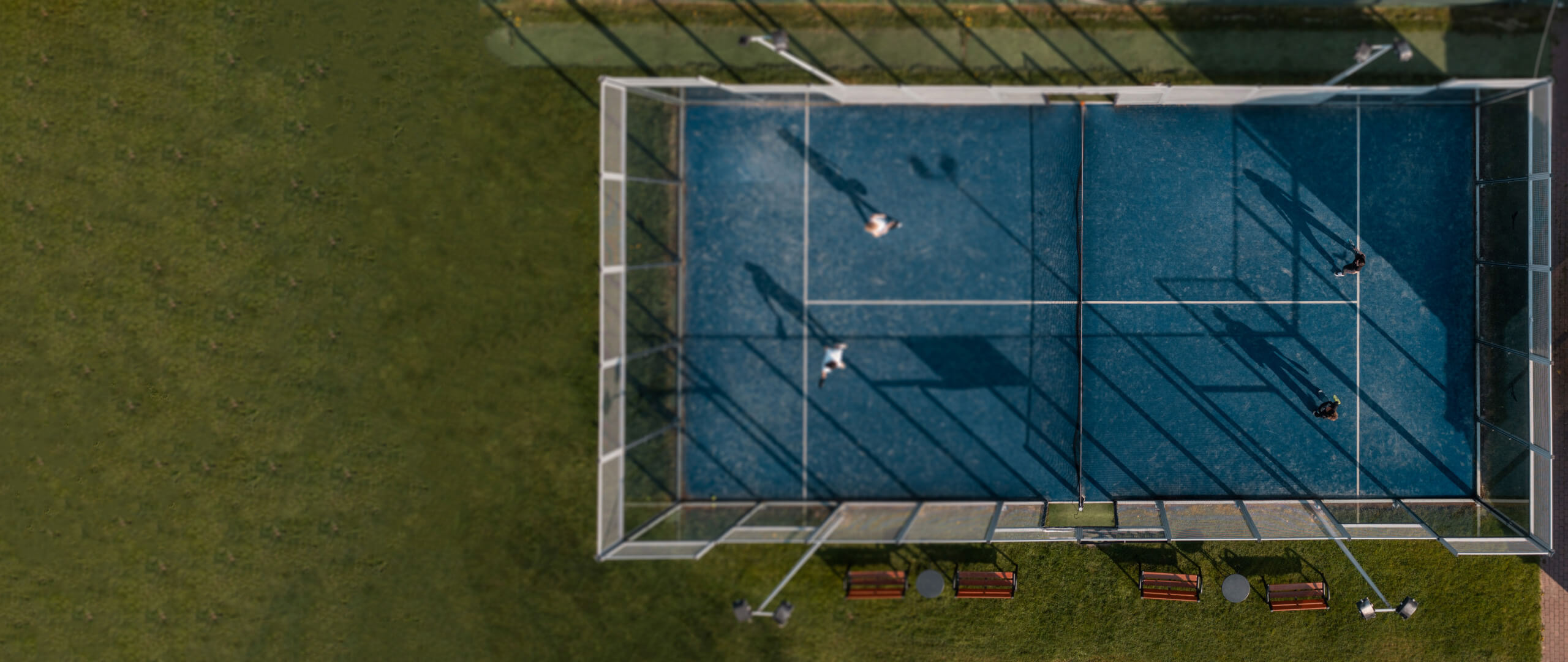 Overhead view of padel players on a court, providing a visual guide to the layout and environment of a padel court in Montreal.